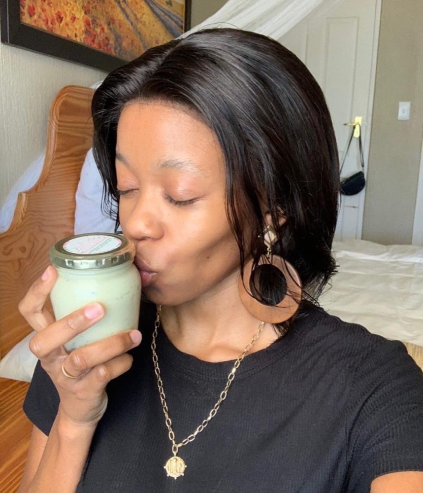 A Sienna customer holding her shea butter jar