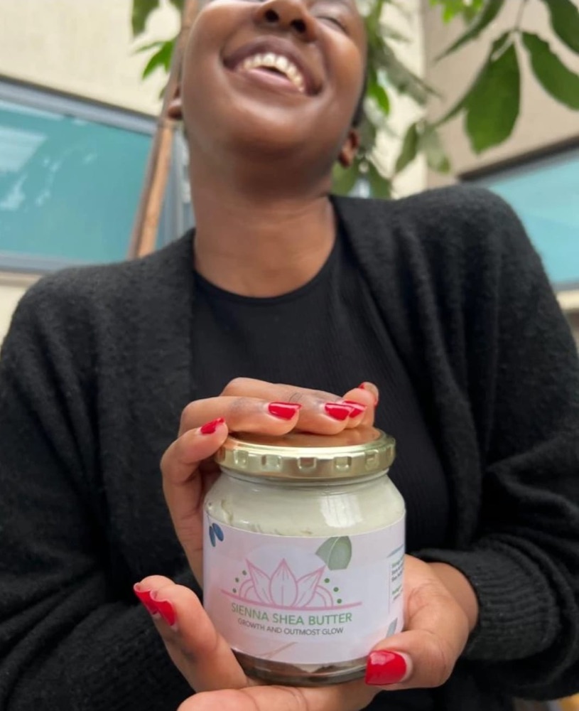 A customer holding a labelled jar of Sienna Shea Butter